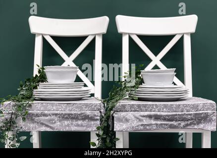 Kitchen composition with a set of dishes on white chairs. Stock Photo
