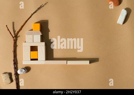 Construction of house from wooden blocks with shadows. Stock Photo