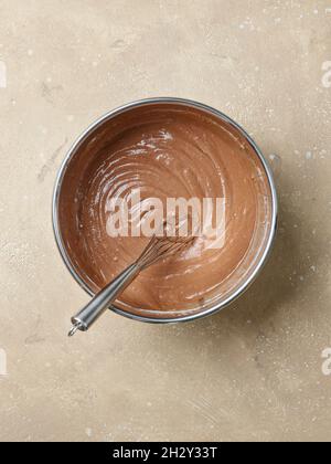 bowl of chocolate cake dough on kitchen table, top view Stock Photo