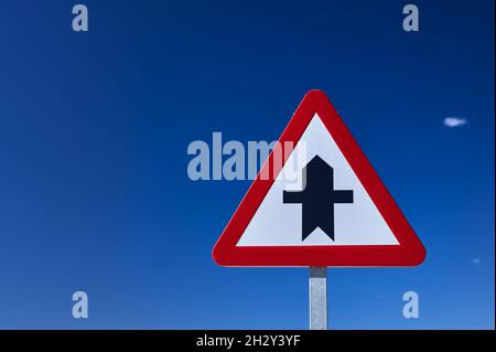 detail of a crossroad ahead traffic sign in blue sky Stock Photo