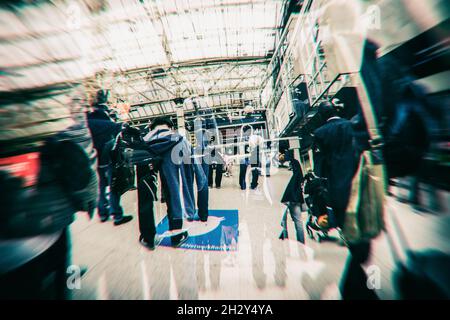 Multiple exposures of Commuters at Charing Cross railway station taken with Fish eye lens in Cross processed colours Stock Photo
