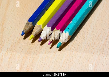 Colouring pencils lined up on a desk Stock Photo