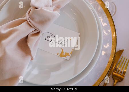 Wedding table setting. Gold plate for the bride close-up. Stock Photo