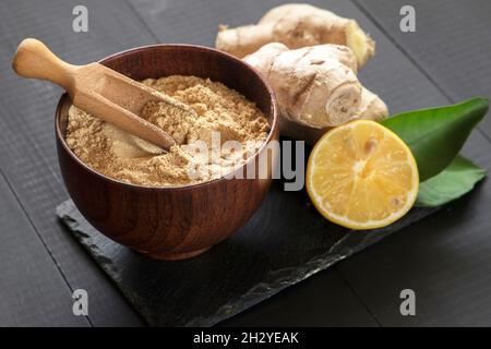ginger root and powder on black stone plate Stock Photo