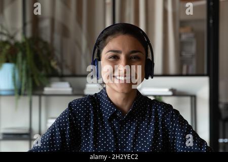 Pleasant young indian woman in headset look at web camera Stock Photo
