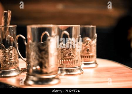 glasses in iron cup holders stand on a table in the evening at dusk Stock Photo