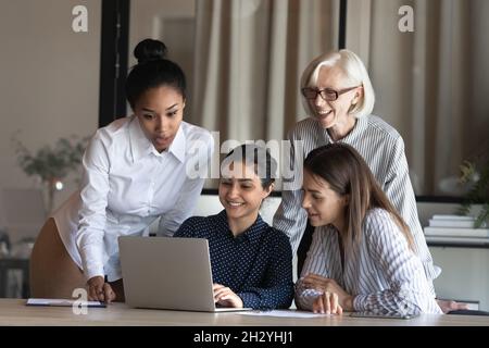 Smiling indian female show original project decision to multiethnic colleagues Stock Photo