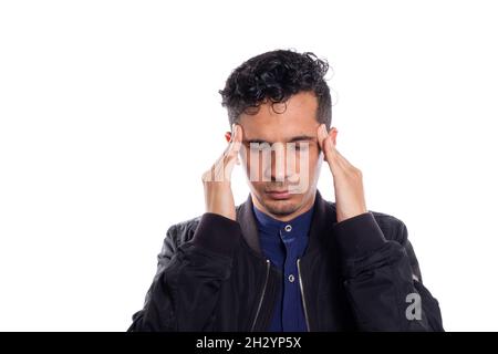 Man with headache isolated on white background. Stressed young latino adult man placing his hands on his head. Person trying to meditate or use Stock Photo