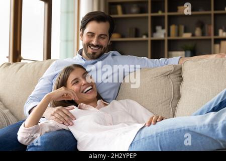 Happy young couple relaxing on cozy sofa. Stock Photo