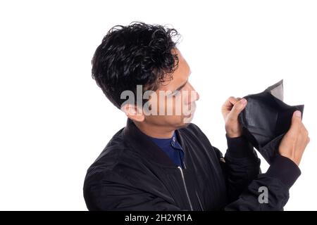 Man showing empty wallet isolated on white background. Sad young latino man with no money. Stock Photo