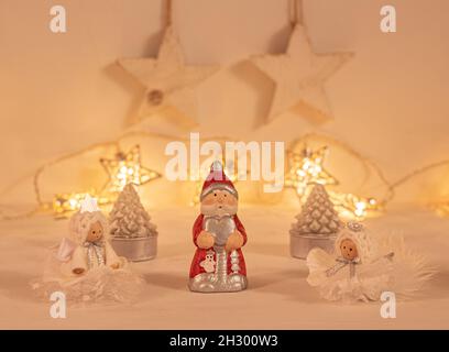 christmas festive scenery showing  christmas ornaments in warm golden light; front view with blurred bokeh star lights background on white wood Stock Photo