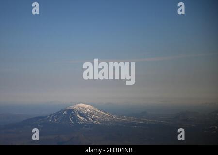 Hekla volcano, Iceland, snow-capped mountain beneath a dusky blue sky with white clouds. Stock Photo