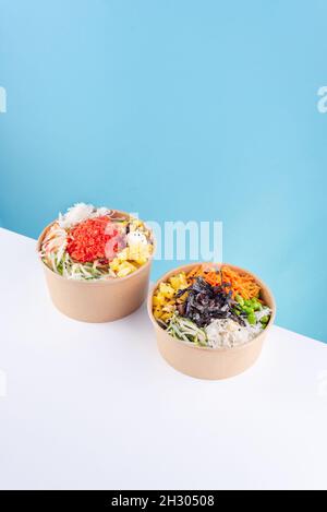 three salad pokes with blue background, asian hawaiian food, chopsticks, carrot, beans, pineapple, soy, jicama, seaweed, healthy food, no people Stock Photo