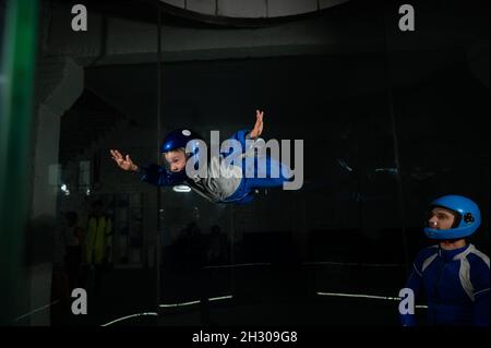 A man teaches a boy to fly in a wind tunnel. Stock Photo