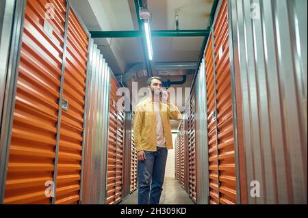 Man talking on smartphone in basement Stock Photo