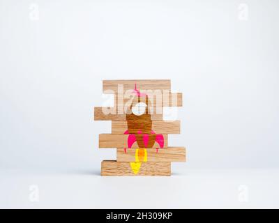 Business startup concept. Wood stack with the jigsaw puzzle with incomplete rocket symbol on white background. Learning for success. Stock Photo