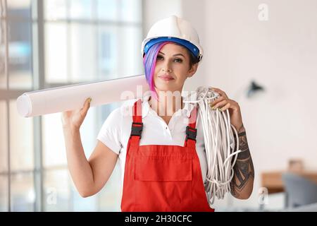 Female electrician with cables in room Stock Photo