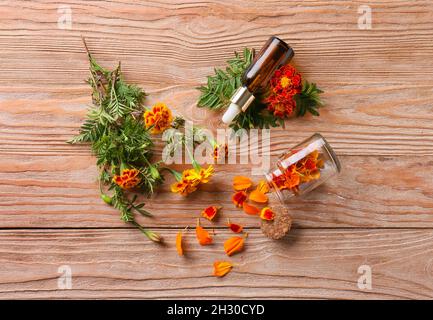 Composition with beautiful marigold flowers and bottle of essential oil on wooden background Stock Photo