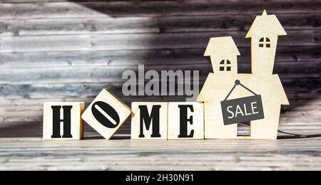 The text house is written on wooden blocks and a dark table. Home concept. Stock Photo