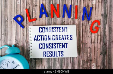 Consisten Action Creates Consistent Results Text in notepad isolated on office desk background Stock Photo