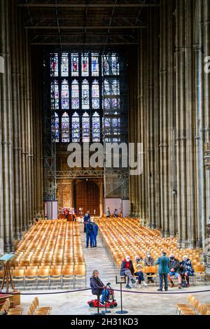 Visitors in the nave at Canterbury cathedral, England, with scaffolding under the roof and at the west end, October 2021. Stock Photo