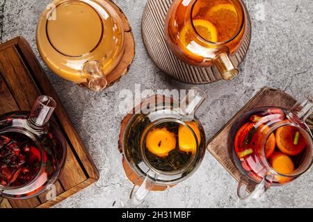 Teapots with various tea on the gray table Stock Photo