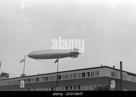 Zeppelin Hindenburg LZ 129 bei der Olympiafahrt über Berlin, Deutschland 1930er Jahre. Zeppeilin Hindenburg LZ 129 at its olympic ride over Berlin, Germany 1930s. Stock Photo
