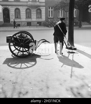 Ein Straßenfeger bei der Arbeit, Deutsches Reich 1930er jahre. A street cleaner working, Germany 1930s. Stock Photo