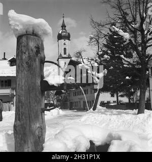 Blick in einen Ortskern mit Kirche und Ladenlokalen, Deutschland 1930er Jahre. view to a twon centre with belfry and a drugstore, Germany 1930s. Stock Photo