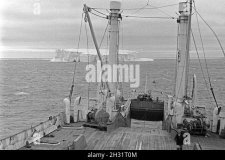 Das Fabrikschiff 'Jan Wellem' der deutschen Walfangflotte vor einem Eisberg im Eismeer der Arktis, 1930er Jahre. Factory vessel 'Jan Wellem' of the German whaling fleet heading an ice berg at the Arctic Sea, 1930s. Stock Photo