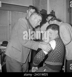 Männer legen einen Verband in einem Erste Hilfe Kurs an, Deutschland 1953. Men learn to set up a bandage in a first aid lesson, Germany 1953. Stock Photo