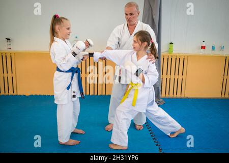 October 23, 2021, Minsk, Belarus, Shotokan Karate Technical Seminar. Girls young athletes kicks under the guidance of an elderly coach Stock Photo