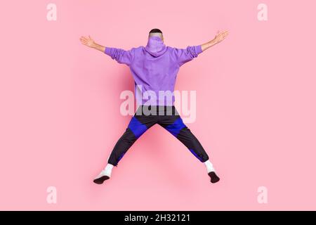 Back rear view full size photo of young anonymous guy fly sporty jump isolated over pink color background Stock Photo