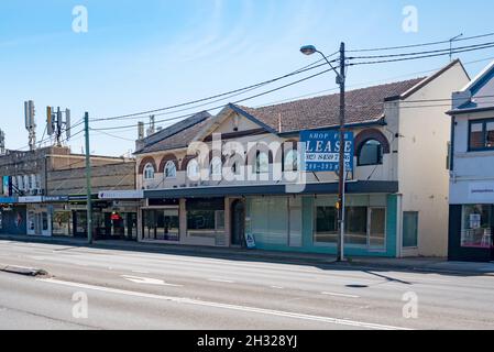 The shopping strip on the Pacific Highway is a mix of building ages including this 2 level multi unit dwelling C. interwar with corbel brick windows Stock Photo
