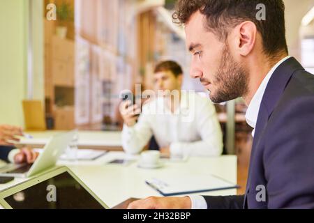 Young business man working concentrated on the computer in a meeting in the office Stock Photo