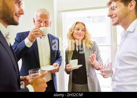 Group of business people in the office on a coffee break having casual small talk Stock Photo