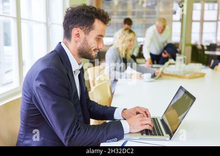 Business man in conference room works on laptop computer as IT specialist Stock Photo