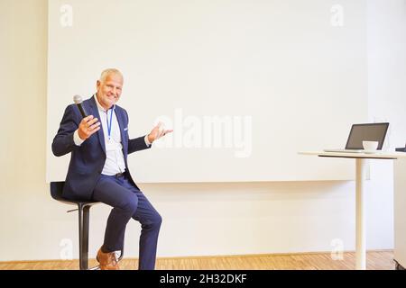 Older businessman as a motivational coach giving a lecture in a seminar Stock Photo