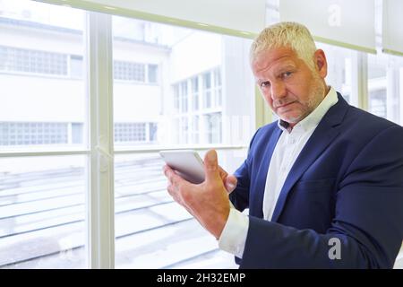 Senior business man as manager or consulting advisor using tablet computer Stock Photo