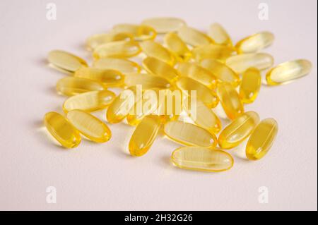 Fish oil capsules close-up. Omega nutrition, vitamin pills on neutral backdrop. Medical supplement tablets for vegan health care with empty space for Stock Photo