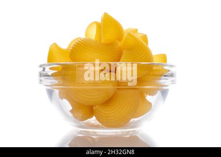 Bright yellow uncooked pasta in a glass bowl, close-up, isolated on white. Stock Photo