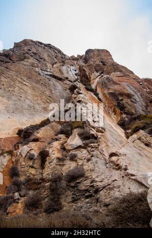 Stunning rocky cliff walls and sky photo from below | Amazing high rock formations climbing into the sky Stock Photo