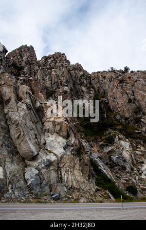 Rocky cliff walls by the road, Amazing rock formations above the road, with cracks, crevices and slopes Beautiful view Stock Photo