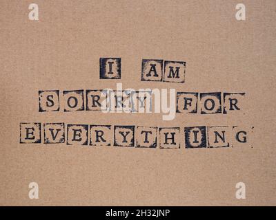 Cardboard with words I am Sorry for Everything  made by black alphabet stamps. Stock Photo