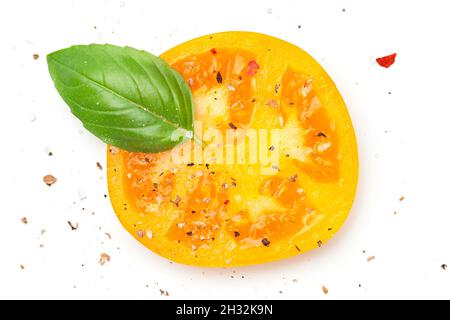 Yellow tomato slice with basil and spices, pepper, salt. Composition isolated on white background. Top view. Flat lay Stock Photo