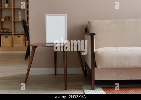 White frame mockup on vintage wooden table. Beige living room design. Home staging and minimalism concept. Scandinavian interior. Stock Photo