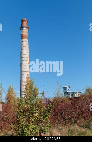 Large brick chimney. Tall factory chimney made of brick against blue sky Stock Photo