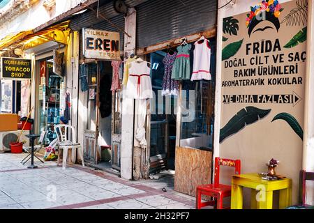 Urla, Turkey - September, 2021: Vintage tailor shop exterior with children's dresses hanging. The oldest historical tailor shop in Urla Izmir Turkey. Stock Photo