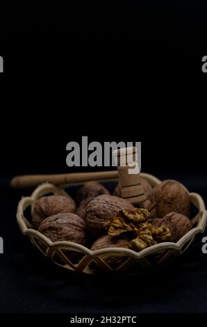 walnuts in a basket with a hammer Stock Photo