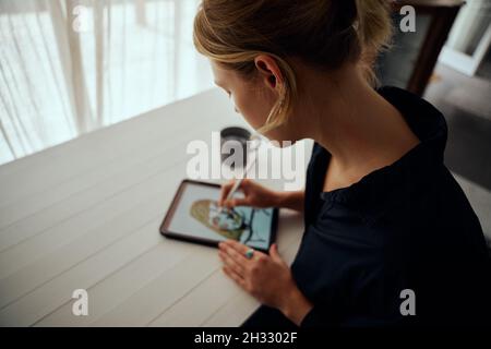 Caucasian female designer working from home creating art on digital tablet Stock Photo